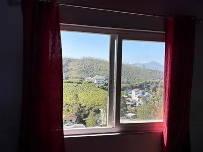 a window with a view of a mountain at Ammukutty's Cottage in Munnar