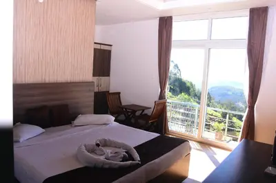 a bedroom with two beds and a large window at Vanam Holidays in Ooty