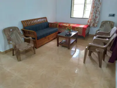 a living room with a couch and chairs and a table at Homely Homes in Kalpetta