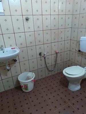 a bathroom with a toilet and a sink at Homely Homes in Kalpetta