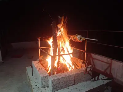 a fire in a brick oven at night at kaffee valley - Kurumbalakotta in Padinjarathara