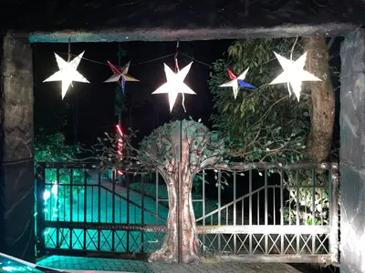 a tree with stars on a gate with a fence at Rai’s Coorg Cave House in Madikeri