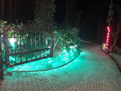 a gate decorated with christmas lights on a sidewalk at Rai’s Coorg Cave House in Madikeri