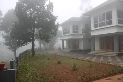 a house on a foggy street in front of a house at The Lavender Woods in Vythiri