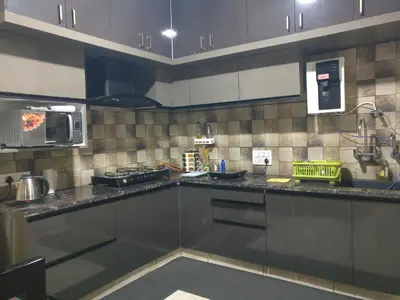 a kitchen with stainless steel cabinets and a microwave at SindooRa in Mysore
