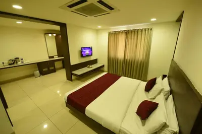 a hotel room with a bed and a television at Hotel LandmarK Coimbatore in Coimbatore
