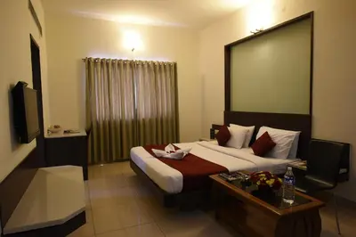 a hotel room with a bed and a table at Hotel LandmarK Coimbatore in Coimbatore
