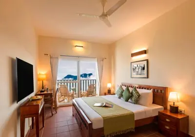 a bedroom with a bed and a television and a balcony at Sleeping Beauty by Nature Resorts and Stays in Coonoor
