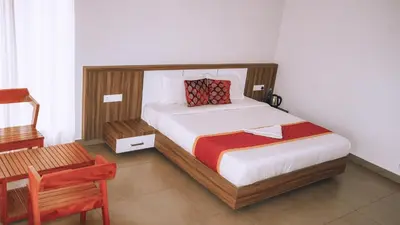 a small bedroom with a bed and a chair at Mountain Vibes Resort Wayanad in Wayanad