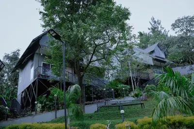 a house with a balcony in front of it at Mountain Vibes Resort Wayanad in Wayanad
