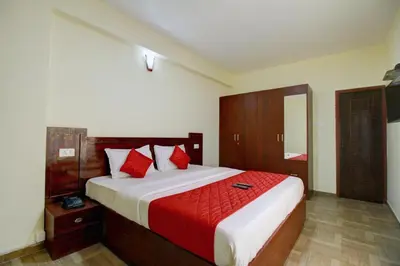 a bedroom with a large bed with red pillows at Pinehill Suites in Ooty