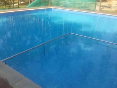 a large blue swimming pool with blue water at Lazo Areca Resort , Coorg in Madikeri