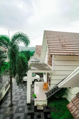 a house with a balcony with a palm tree at SkYVIEW VILLA in Athirappilly
