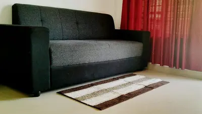 a couch in a living room with a rug on the floor at SkYVIEW VILLA in Athirappilly