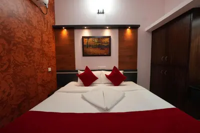 a bedroom with a large bed with red pillows at Hotel Jothi Grand in Coimbatore