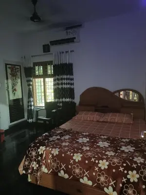 a bedroom with a bed with a brown bedspread with flowers at Oxygen Home Stay in Agali