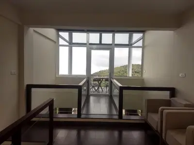 a living room with a large window and a staircase at DWELLINGTON in Kotagiri