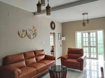 a living room with a couch and two chairs at INN THE MOUNTAIN'S in Kodaikānāl