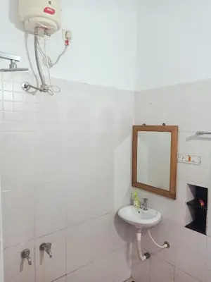 a white bathroom with a sink and a mirror at Moon moon Garden in Thamarassery