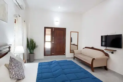 a living room with a couch and a blue rug at StayVista at Ivory Hill Madikeri including breakfast 3 Bhk Villa in Madikeri