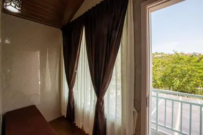 a room with a large window and a balcony at Blossom Inn in Coonoor
